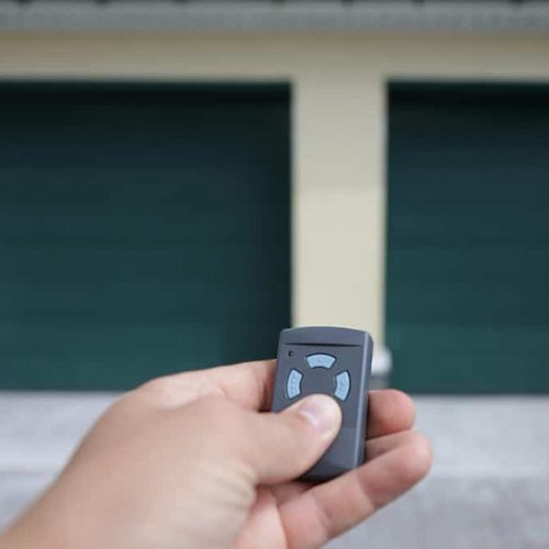 homme-tient-dans-sa-main-telecommande-qui-ouvre-porte-du-garage